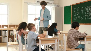 Öğrenci ödevlerine bakarken sınıfta yürüyen yetenekli bir öğretmen. Sınav yaparken ya da sınıfta ödev yaparken akıllı çocuk defterini kontrol eden profesyonel bir eğitmen. Pedagoji.