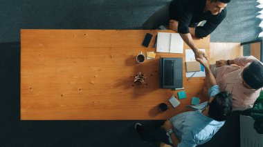 İş adamlarının mali grafiğe bakarken anlaşma yapmak için el sıkıştıklarını gördüm. Masada borsa grafiğiyle pazarlama stratejisi planlayan çeşitli insanlar. Cemaat.