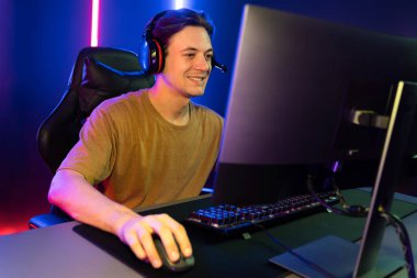 Kazanmak için çevrimiçi oyun oynayan akıllı flama makinesinin sunucu kanalı, neon ışıklı odada seçilen takım yarışması için izleyicilerle birlikte canlı yayında canlı yayında kulaklık takıyor. Bireysel.