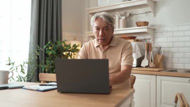 Üst düzey bir iş adamı evdeki belgeleri incelerken dizüstü bilgisayarda çalışıyor. Orta yaşlı yönetici oturma odasında otururken bilgisayar kullanarak rapor yazıyor ve finansal tablolara bakıyor. Myrmidon.