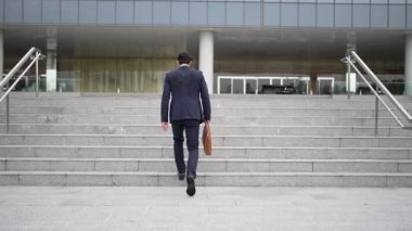 Ofise giderken merdivenlerden çıkan başarılı bir iş adamı bacağı. Müdürün iş yerini değiştirmesi, yeni bir şey keşfetmesi, gelişmesi, terfi etmesi ya da gün ışığına çıkması. Arkadan bak. Sevinçli..