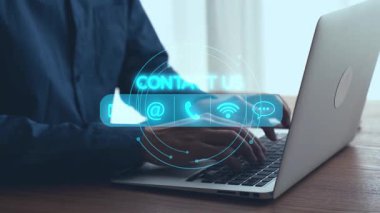 Profesyonel bir birey modern ofis ortamında dizüstü bilgisayar kullanır. Sanal iletişim ve bağlantı seçeneklerini vurgulayarak sahneyi dijital temas simgeleri kaplar. Dörtgen
