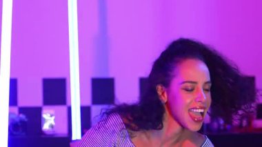 Stüdyoda mor ışıkla sokak dansı yapan İspanyol sokak dansçılarına yakın çekim. Profesyonel sanatçı şık kumaşla enerjik bir hareket sergiler. Çılgın, komik. Yarı vücut. Mutluluk.