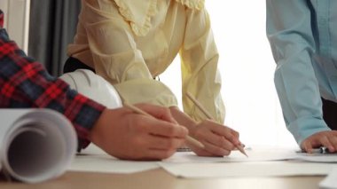 Mimari döküman, ölçüm araçları ve ahşap blokların modern ofiste etrafa saçıldığı masa üzerine planlar yapma konusunda akıllı mimar ve güvenlik mühendisi tartışması. - Yakın çekim. Tanımlama.