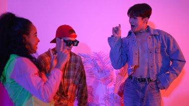 İspanyol hipster renkli kıyafetler giyer ve serbest stil müziğe el sallar. Profesyonel break dansçı neon ışıklarıyla ve modern stüdyo arkadaşlarıyla coşkuyla dans ediyor. Mutluluk.