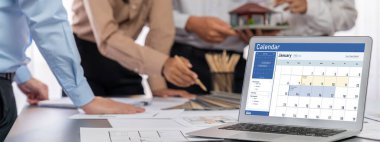 İç mimar tasarımcı grubu, daha kesin tasarım için planlar ve dizüstü bilgisayar ekran mimari yazılımı üzerinde birlikte tartışıyorlar. Modern ev tasarımı ve yenileme. İçgörü