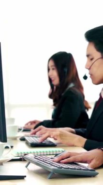 Ofiste çalışan kulaklık takan işadamları uzak müşteri ya da meslektaşlarını desteklemek için çalışıyorlar. Arama merkezi, tele pazarlama, müşteri destek acentesi telefon görüşmesinde hizmet sunar.