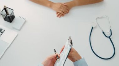 Klinikteki ya da hastane ofisindeki doktor randevusuna katılan hasta, tıbbi tedavi seçeneklerini tartışıyor ve muayene sonuçlarını ya da hastalıkla ilgili tıbbi kayıtları açıklıyor. Ağır çekim. Katı.