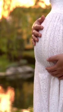 Hamile bir kadın, çocuğuna bakarken bahçe evinde mutlu bir hayat yaşıyor. Hamile karnında bebek taşıyan hamile bir anne. Doğum öncesi bakım ve kadın hamileliği konsepti.