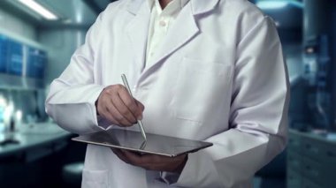 Doktorun tableti tutarken laboratuvarda bulanık arka planda yüzen DNA hologramıyla kalemi işaret etmesini kapat. Genetik araştırmayı kontrol eden ve gen terapisi kullanan bir tıp çalışanı. İyileştirici.