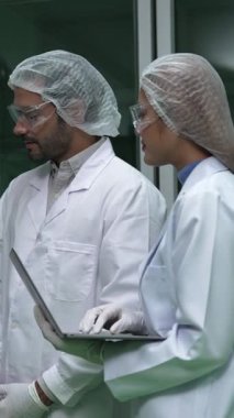 Two scientist in professional uniform working in curative laboratory for chemical and biomedical experiment