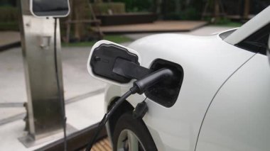 Elektrikli araba parkı ve şarj istasyonunun yanında şarj edilen enerji konseptinin sürdürülebilirliği. Çevresel koruma için yenilenebilir enerji tarafından kullanılan elektrikli araç.