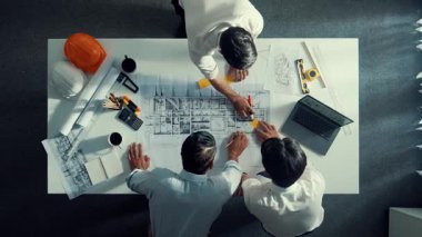 Mühendis ekibiyle tasarım planlarken iç mimar yazımının yukarıdan aşağı görüntüsü yapışkan notta. Çeşitli mimarlar ve usta yöneticilerden oluşan bir grup bina inşaatı arıyor. Hizalama.