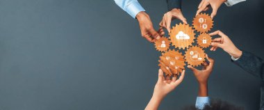 Çeşitli eller, takım çalışmasını ve yenilikçiliği sembolize eden ahşap vitesleri, strateji ve modern kurumsal ortamlarda iş kavramları için idealleri sembolize eder. Dostluk