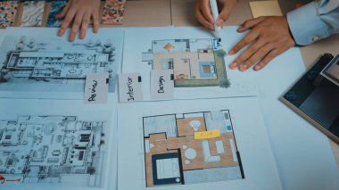 İki el, iç tasarım ve proje planlama sürecini çizimler ve renk paletleri ile göstererek, işbirlikçi bir çalışma alanındaki mimari düzenler ve notlarla etkileşime girer. SACTR