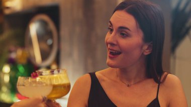 Lüks tezgah barında votka kokteyli içen güzel bir kadının tadını çıkarın. Arkadaşlarla kadeh kaldırın. Gece hayatı lüksünün özünü yakalayın. Vinosity.