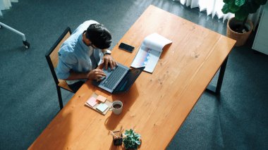 Finans tablosuna bakarken, iş adamının dizüstü bilgisayarla çalışmasının en üst görüntüsü. Toplantı masasında oturmuş bilgisayar kullanarak ekrana bakarken verileri analiz eden sıradan bir bez yöneticisi. Cemaat.