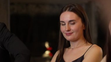 Lüks bir kokteyl barında grup arkadaşıyla konuşan güzel bir kadının portresi. Gece kulübünde sosyetik etkileşim için doğal yüz güzelliğini kostüm içinde yakalamak. Vinosity.