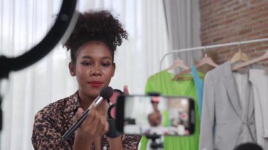 Kadın nüfuzlu kişi canlı yayında video görüntülerini çekiyor. Makyaj çok önemli sosyal medya ya da blog. Kozmetik stüdyosu ışıklandırmalı mutlu genç kız çevrimiçi pazarlama oturumu yayını için..