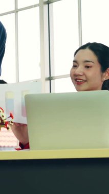 İki iş adamı toplantı odasında proje stratejisi hakkında konuşuyor. İş adamı, mali veri raporu hakkında sohbet ve tavsiyelerde bulunurken, modern işyerindeki iş arkadaşıyla proje planlamasını tartıştı.