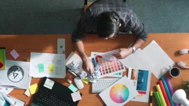 Paletler ve buruşuk kağıtlar üzerindeki tasarımcı görüşü. Yetenekli bir iş adamının toplantı masasında uyurken fikri tükenir. Proje yöneticisi buruşmuş ve kağıt fırlatmış. Sempozyum.