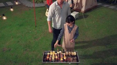 Aile birlikte bahçede kamp kurar, baba ve kız aile bireyleri için ızgara yapar. Doğayla iç içe olmak için açık hava kamp aktiviteleri ve genç nesil çapraz kuşaklarla zaman geçirmek için. Uyumsuzluk.