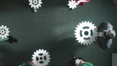 Yetenekli iş adamlarının bir araya gelip beyaz giysi toplaması. Çeşitli takımlar, ağ iletişimi ve veri tabanı bağlantısı olan dişlileri toplamak ya da yerleştirmek için birlikte çalışıyorlar. Sempozyum.