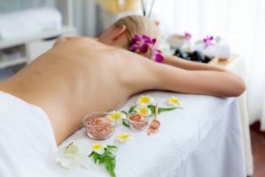 Lüks spa salonlarında sıcak mum ışığında cilt bakımı yaptıran kadın müşteri. Sağlık Spa vücut fırçasında tuz temizleme güzellik tedavisi. Sessiz.