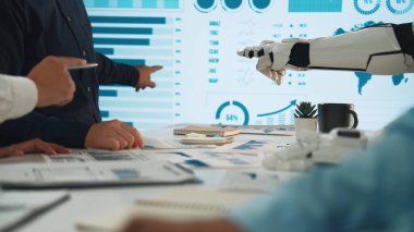 İnsan eli ve robotik kolun yüksek teknoloji ürünü bir ekranda gösterilen veri içgörülerini analiz etmek için işbirliği yaptığı modern bir toplantı. Noogenesis