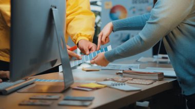 İki yaratıcı profesyonel, tasarım malzemeleriyle dolu modern bir çalışma masasında renk paletleri ve görsel fikirleri keşfeden üretken bir tasarım tartışmasına girişiyor. SACTR