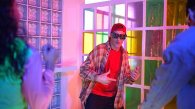 Kafkas dansçısı dans ederken çeşitli arkadaşları gece kulübünde neon ışıkta ayak seslerine bakıyor. Çoklu etnik kökenli hipsterin serbest stil müziğe geçişi ve mutlu bir adamın kameraya bakışıyla. Mutluluk.