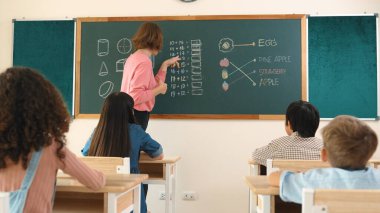 Zeki öğretmen sınıfta fikri açıklarken sevimli öğrenci ödevlerini kontrol ediyor. Not defterine bakıp matematik teorisinden çocuğa bahsederken sınıfta dolaşan çekici bir eğitmen. Pedagoji.