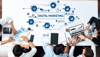 Çeşitli bir ekip, çeşitli cihazlar ve araçlar kullanarak dijital pazarlama stratejileri üzerine odaklanarak, veri eğilimlerini analiz ederek, işbirlikçi bir iş toplantısı düzenler. Dostluk