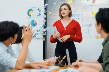 Erkek proje yöneticisinin yakın plan görüntüsü soru sormak için el kaldırırken, genç güzel lider zihin haritası ve renkli yapışkan notlar kullanarak iş projesini kendinden emin bir şekilde sunuyor. Tertemiz..