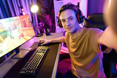 Akıllı oyun flamasının sunucu kanalı kameraya bakarken savaş takımının arka plandaki savaş gemisine silah çekmesini dijital neon siber odada kulaklık takmasını sağlıyor. Bireysel.