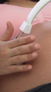 Hamile bir kadın çocuğuna bakarken kendini mutlu hissediyor. Hamile karnında bebek taşıyan hamile bir anne. Doğum öncesi bakım ve kadın hamileliği konsepti.