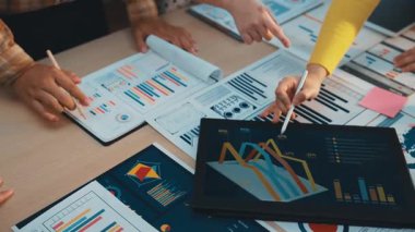 İş dünyasından profesyoneller, stratejik planlama amaçlı belge ve dijital ekranlarda gösterilen tablo ve grafikleri analiz ederek, işbirlikçi bir toplantıya giriyorlar. SACTR