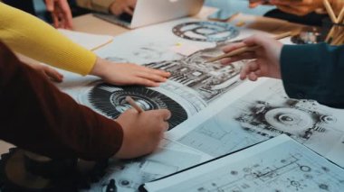 Modern bir çalışma alanında takım çalışması, yenilik ve odaklanmış tartışmaları vurgulayan, karmaşık teknik çizimler ve mekanik planlar üzerinde işbirliği yapan dinamik sahne gösterici mühendisler. SACTR