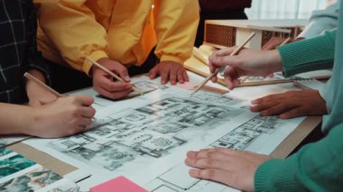 Dinamik bir ekip, canlı bir ofis ortamında mimari bir planı, işbirliği ve yaratıcılığı tartışırken yaratıcı bir beyin fırtınası yapıyor. SACTR