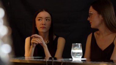 Güzel bir kadının portresi, lüks bir tezgah içecek barında arkadaşlarıyla sohbet edip, dilimlenmiş portakallı gazoz içerken. Kulüpte sosyetenin özünü yakalamak. Vinosity.