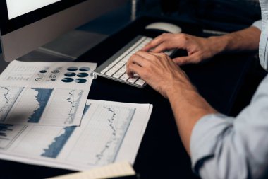 Akıllı iş adamı iş paragrafı dinamik pazarlama analizi planını analiz ediyor. Kağıt kağıtları ve bilgisayar monitörü raporlarını gece evdeki belge verileriyle karşılaştırmak için hazırlıyor. Bireysel.