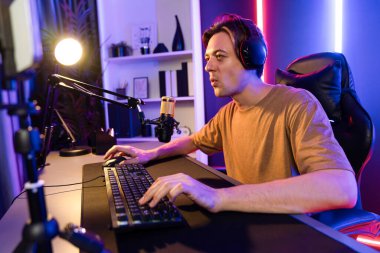 Kazanmak için çevrimiçi oyun oynayan akıllı flama makinesinin sunucu kanalı, neon ışıklı odada seçilen takım yarışması için izleyicilerle birlikte canlı yayında canlı yayında kulaklık takıyor. Bireysel.