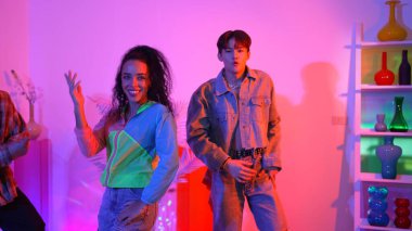 Çekici mutlu dansçı kameraya bakarken zeki kadın neon ışıkla kafiyeli hareket ediyor. Profesyonel İspanyol şarkıcı çeşitli arkadaşlarıyla renkli kıyafetler giyerken break dans yapıyor. Mutluluk.