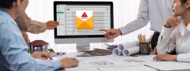 İç mimar tasarımcı grubu, daha kesin tasarım için planlar ve dizüstü bilgisayar ekran mimari yazılımı üzerinde birlikte tartışıyorlar. Modern ev tasarımı ve yenileme. İçgörü