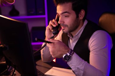 Akıllı iş adamı, telefon masasındaki ortağını ya da yatırımcıyı arıyor, hedef pazar veritabanı üzerinde tartışıyor, satış kanalı disiplinlerini analiz etmek için Neon Dark Light Room 'daki ürün servisini inceliyor. Tahmin et..