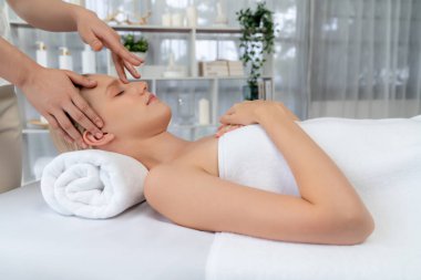 Kafkasyalı kadın stres önleyici kafa masajından ve lüks tatil beldesi ya da otel spa salonundaki modern ışık ortamında yüz güzelliği eğlencelerini şımartmaktan hoşlanıyor. Sessiz.