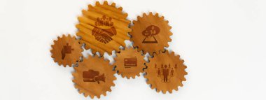İşle ilgili projeler için ideal bir şirket ortamında takım çalışmasını ve işbirliğini temsil eden oymalı simgelerin yer aldığı ahşap dişliler için yaratıcı bir düzenleme. Dostluk