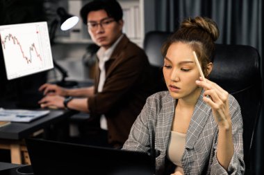 Modern ofiste gece geç saatlerde arka tarafta çalışan iş arkadaşı ile birlikte veri analizi sosyal medya çevrimiçi proje işini rapor etmek için bilgisayara odaklanan iş kadınının ciddi yüzü. İnfobahn.