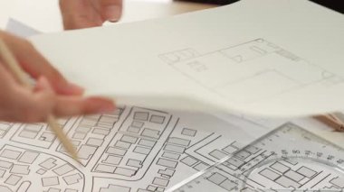 Mimari döküman, ölçüm araçları ve ahşap blokların modern ofiste etrafa saçıldığı masa üzerine planlar yapma konusunda akıllı mimar ve güvenlik mühendisi tartışması. - Yakın çekim. Tanımlama.