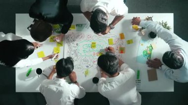 Profesyonel iş adamlarının zihin haritasını kullanarak beyin fırtınası yapmak için birlikte çalıştıklarına dair üst düzey bir görüş. Akıllı yöneticilerin sürdürülebilir enerji hakkında konuştuğu ve tartıştığı hava görüntüsü. Hizalama.